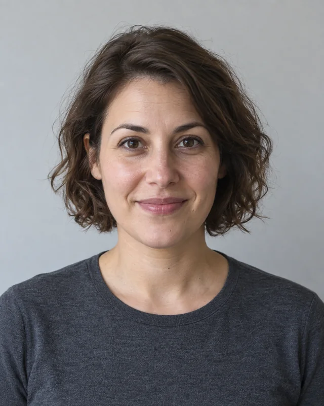 Original portrait of a short-haired woman in a charcoal top against a gray background